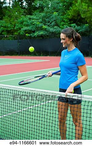 25 year old brunette woman on a tennis court playing with racquet and ball View Large Photo Image Stock Image - 25 year old brunette woman on a tennis court playing with racquet and ball. Fotosearch