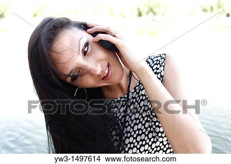25 year old pretty woman outdoors talking by cell phone View Large Photo Image Picture - 25 year old pretty woman outdoors talking by cell phone. Fotosearch