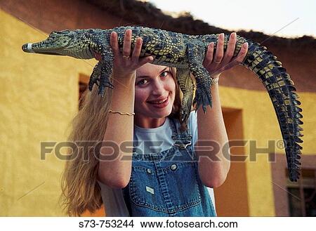 25 year old woman holding a caiman View Large Photo Image Picture - 25 year old woman holding a caiman. Fotosearch