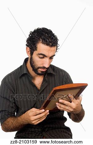 25 years old Middle Eastern man looking at a framed picture. View Large Photo Image Stock Photo - 25 years old Middle Eastern man looking at a framed picture.. Fotosearch