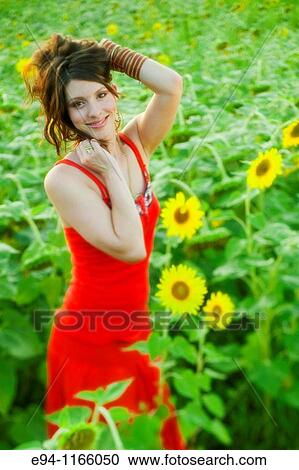 26 year old brunette woman wearing a red dress in a field of sunflowers View Large Photo Image Stock Image - 26 year old brunette woman wearing a red dress in a field of sunflowers. Fotosearch