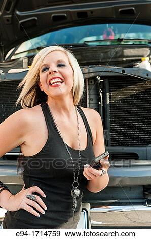 29 year old blond woman in front of a big pick up truck holding her cell phone with a look of exasperation View Large Photo Image Stock Photo - 29 year old blond woman in front of a big pick up truck holding her cell phone with a look of exasperation. Fotosearch