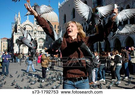 Stock Image - 29 year old woman with pigeons in St Mark's Square, Venice Veneto, Italy. Fotosearch