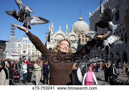 Stock Image - 29 year old woman with pigeons in St Mark's Square, Venice. Veneto, Italy. Fotosearch
