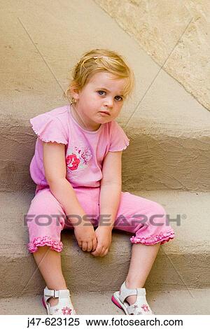 2_3 year old girl sitting on a step looking into camera, looking really miserable View Large Photo Image Stock Photography - 2_3 year old girl sitting on a step looking into camera, looking really miserable. Fotosearch