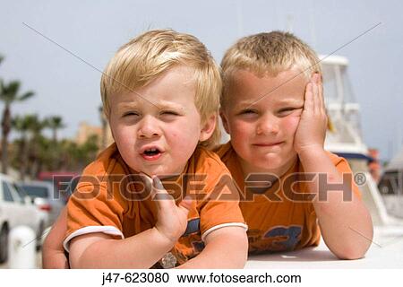 3 and a 5 year old brothers, lying on a wall together, Spain. View Large Photo Image Stock Image - 3 and a 5 year old brothers, lying on a wall together, Spain.. Fotosearch