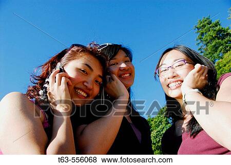 3 asian women each using cell phones View Large Photo Image Stock Photo - 3 asian women each using cell phones. Fotosearch