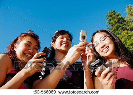 3 asian women each using cell phones View Large Photo Image Stock Photo - 3 asian women each using cell phones. Fotosearch