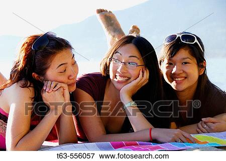 3 asian women laying on towel at beach together View Large Photo Image Stock Photo - 3 asian women laying on towel at beach together. Fotosearch