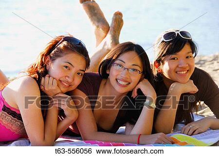 3 asian women laying on towel at beach together View Large Photo Image Stock Photograph - 3 asian women laying on towel at beach together. Fotosearch