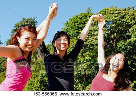 3 asian women standing together with arm in air View Large Photo Image Stock Photograph - 3 asian women standing together with arm in air. Fotosearch