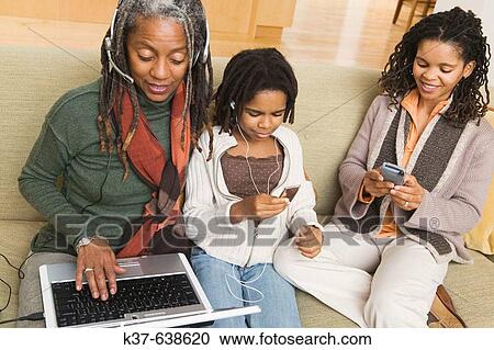 3 generations of African American family at home using various technologies including ipod, laptop, blackberry. View Large Photo Image Stock Image - 3 generations of African American family at home using various technologies including ipod, laptop, blackberry.. Fotosearch
