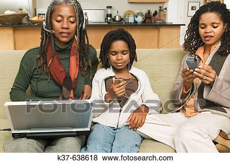 3 generations of African American family at home using various technologies including ipod, laptop, blackberry. View Large Photo Image Stock Photo - 3 generations of African American family at home using various technologies including ipod, laptop, blackberry.. Fotosearch
