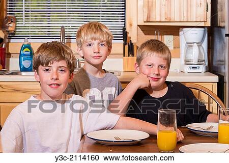 3 male children, age 6, 9, and 12 sitting at a kitchen dining table, smiling. Orange juice and blank plates are on the table. View Large Photo Image Stock Image - 3 male children, age 6, 9, and 12 sitting at a kitchen dining table, smiling. Orange juice and blank plates are on the table.. Fotosearch