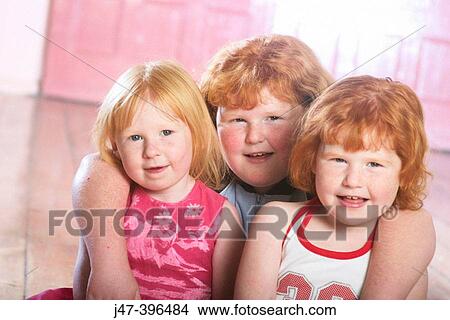 Picture - 3 red haired sisters, smiling into camera, arms round each other. Fotosearch