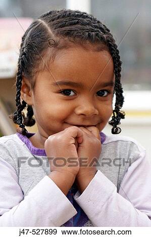 3 year old black girl playing at nursery, smiling into camera, with braids in her hair and her hands up to her face View Large Photo Image Stock Photo - 3 year old black girl playing at nursery, smiling into camera, with braids in her hair and her hands up to her face. Fotosearch