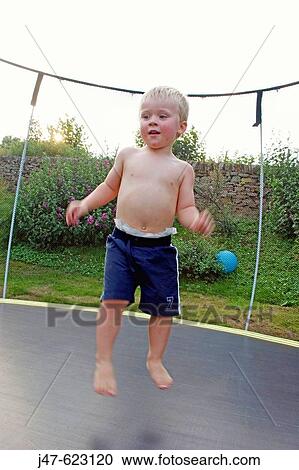 3 year old boy bouncing on a trampoline. View Large Photo Image Stock Image - 3 year old boy bouncing on a trampoline.. Fotosearch