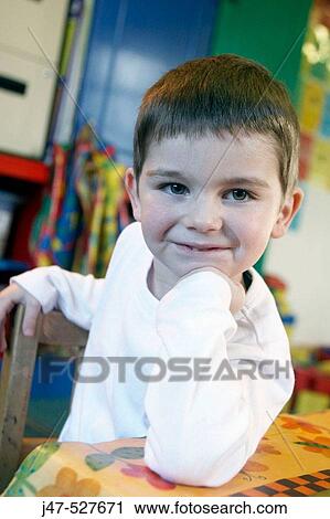 3 year old boy looking into camera at nursery, smiling, chin on his hand View Large Photo Image Stock Image - 3 year old boy looking into camera at nursery, smiling, chin on his hand. Fotosearch
