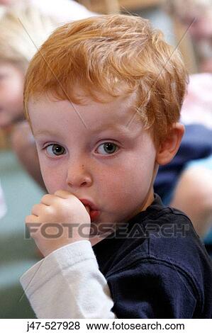 Stock Photo - 3 year old boy, looking into camera, sucking his thumb. Fotosearch