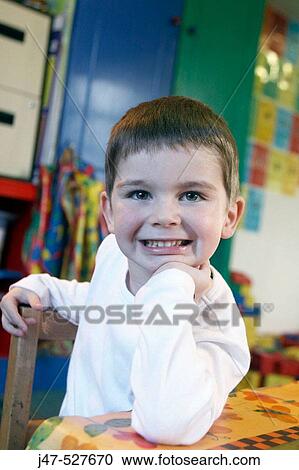3 year old boy looking off camera at nursery, smiling, chin on his hand View Large Photo Image Stock Image - 3 year old boy looking off camera at nursery, smiling, chin on his hand. Fotosearch
