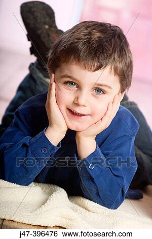 3 year old boy lying on the floor hands under his chin, smiling into camera View Large Photo Image Stock Photograph - 3 year old boy lying on the floor hands under his chin, smiling into camera. Fotosearch