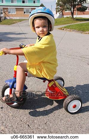 Stock Image - 3 year old boy on a tricycle. Fotosearch