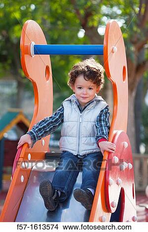 Picture - 3 year old boy playing in a playground. Fotosearch