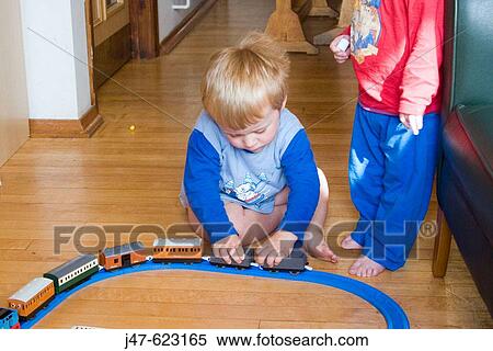 3 year old boy sitting on the floor playing with a train track View Large Photo Image Stock Photography - 3 year old boy sitting on the floor playing with a train track. Fotosearch