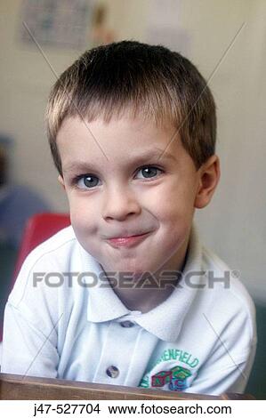 Picture - 3 year old boy smiling into camera at nursery. Fotosearch