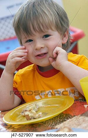 3 year old boy, smiling into camera, at nursery, eating his dinner View Large Photo Image Stock Photo - 3 year old boy, smiling into camera, at nursery, eating his dinner. Fotosearch