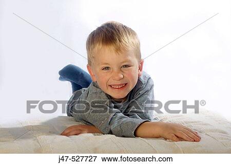 3 year old boy, smiling into camera, lying on the floor in studio View Large Photo Image Stock Photo - 3 year old boy, smiling into camera, lying on the floor in studio. Fotosearch