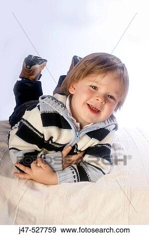 3 year old boy smiling into camera lying on his tummy View Large Photo Image Stock Photo - 3 year old boy smiling into camera lying on his tummy. Fotosearch
