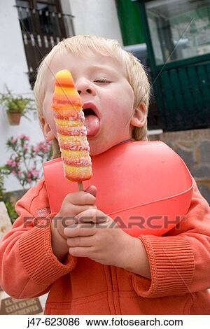 Stock Photograph - 3 year old boy sucking a lolly. Fotosearch