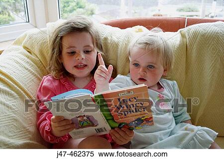 3 year old girl and 18 month old baby girl, sitting on the settee, reading a bedtime story View Large Photo Image Stock Photography - 3 year old girl and 18 month old baby girl, sitting on the settee, reading a bedtime story. Fotosearch