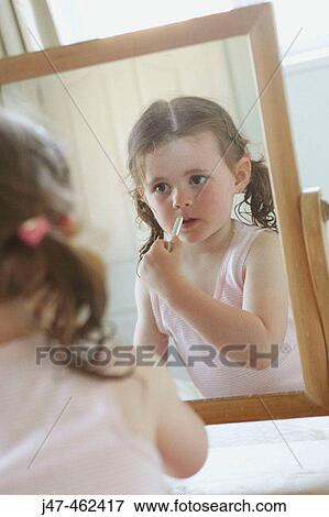 3 year old girl applying lipstck in a mirror View Large Photo Image Stock Photo - 3 year old girl applying lipstck in a mirror. Fotosearch