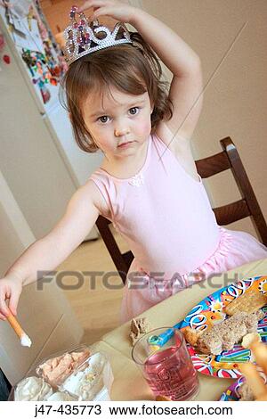 3 year old girl at a party, wearing a crown, with a table full of food in front of her View Large Photo Image Stock Image - 3 year old girl at a party, wearing a crown, with a table full of food in front of her. Fotosearch