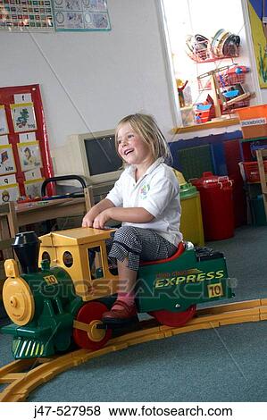 3 year old girl, at nursery, playing on a ride on train, laughing View Large Photo Image Stock Photo - 3 year old girl, at nursery, playing on a ride on train, laughing. Fotosearch