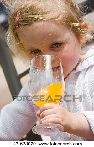 3 year old girl having a drink of orange out of a glass View Large Photo Image Stock Photo - 3 year old girl having a drink of orange out of a glass. Fotosearch