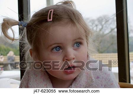 Stock Photography - 3 year old girl looking off camera, a serious expression, with huge blue eyes. Fotosearch