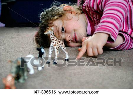3 year old girl lying down on the floor playing with toy animals View Large Photo Image Stock Photography - 3 year old girl lying down on the floor playing with toy animals. Fotosearch