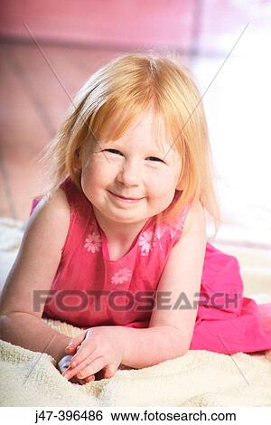 3 year old girl lying on her tummy, smiling into camera View Large Photo Image Stock Photograph - 3 year old girl lying on her tummy, smiling into camera. Fotosearch