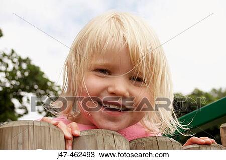 3 year old girl outside leaning over a fence smiling View Large Photo Image Stock Image - 3 year old girl outside leaning over a fence smiling. Fotosearch