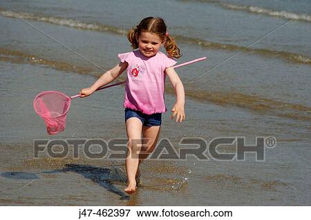 3 year old girl running out of the sea with a net, laughing View Large Photo Image Stock Photo - 3 year old girl running out of the sea with a net, laughing. Fotosearch