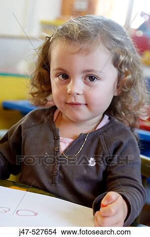 3 year old girl sitting at nursery drawing, smiling off camera View Large Photo Image Picture - 3 year old girl sitting at nursery drawing, smiling off camera. Fotosearch