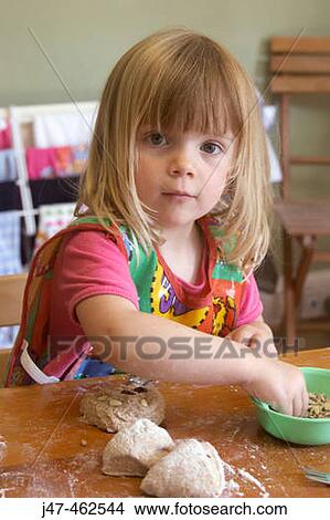 3 year old girl sitting at the table making bread View Large Photo Image Picture - 3 year old girl sitting at the table making bread. Fotosearch