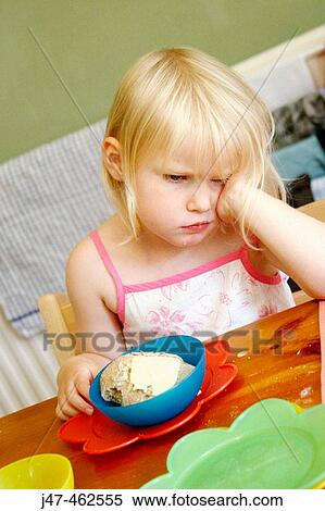 3 year old girl sitting at the table, with food infront of her, looking miserable View Large Photo Image Stock Photography - 3 year old girl sitting at the table, with food infront of her, looking miserable. Fotosearch