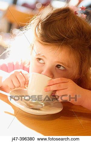 3 year old girl sitting in a cake drinking from tiny china cup View Large Photo Image Stock Image - 3 year old girl sitting in a cake drinking from tiny china cup. Fotosearch