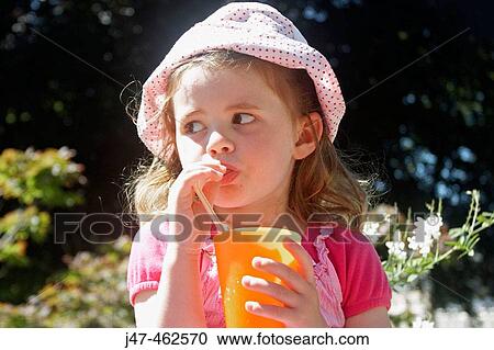 3 year old girl sitting on a wall outside, drinking orange through a straw View Large Photo Image Stock Image - 3 year old girl sitting on a wall outside, drinking orange through a straw. Fotosearch