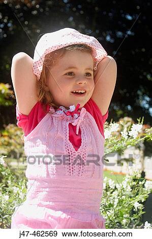 3 year old girl sitting on a wall outside, with her hands behind her head, smiling View Large Photo Image Stock Photo - 3 year old girl sitting on a wall outside, with her hands behind her head, smiling. Fotosearch