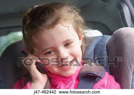 3 year old girl smiling as she talks into a mobile phone in her carseat View Large Photo Image Stock Image - 3 year old girl smiling as she talks into a mobile phone in her carseat. Fotosearch